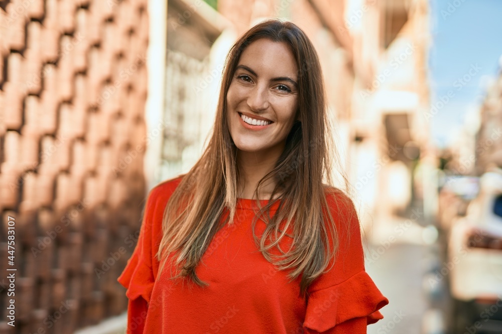 Fototapeta premium Young hispanic woman smiling happy standing at the city.