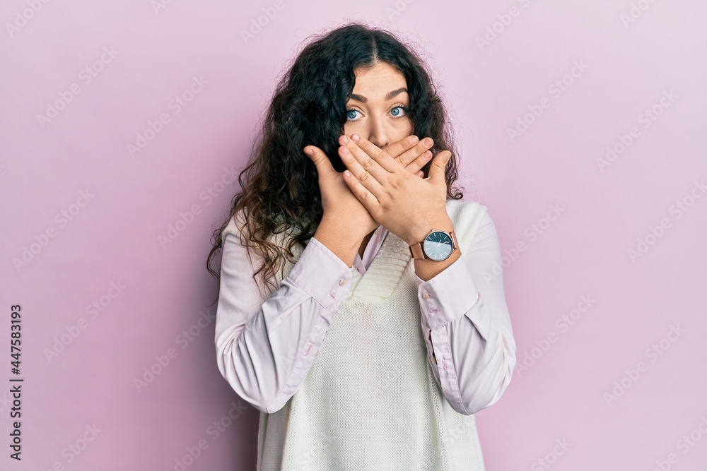 Young brunette woman with curly hair wearing casual clothes shocked covering mouth with hands for mistake. secret concept. Young brunette woman with curly hair wearing casual clothes shocked covering mouth with hands for mistake. secret concept.
