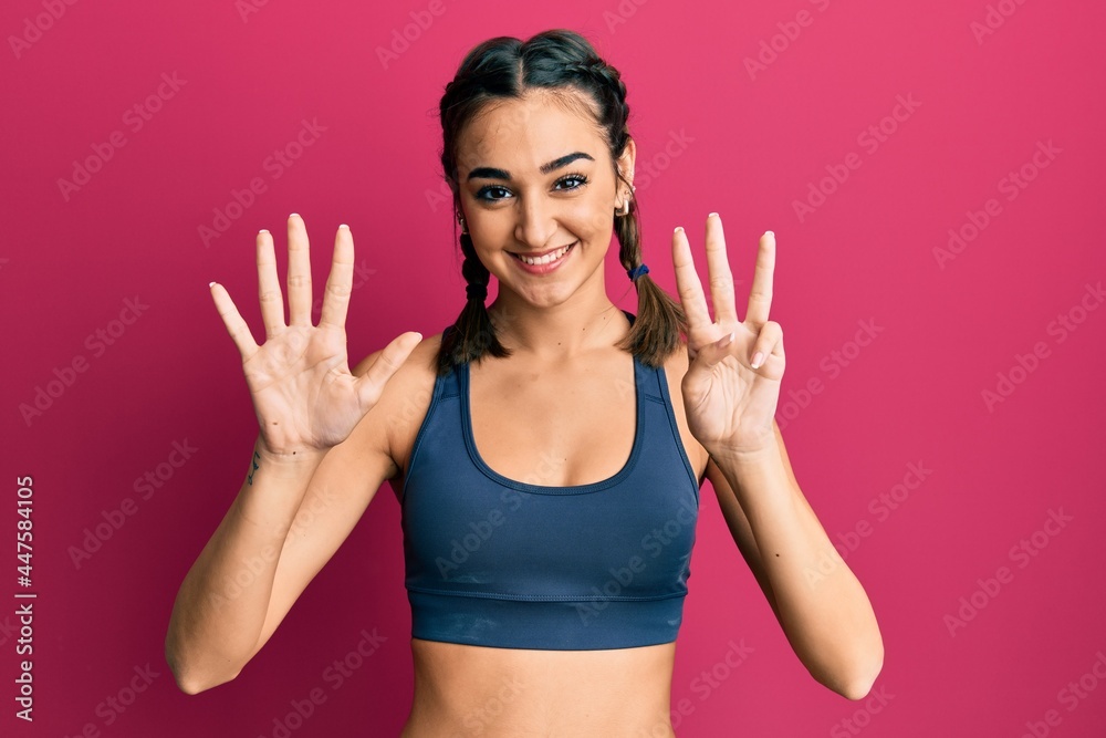 Young brunette girl wearing sportswear and braids showing and pointing up with fingers number nine while smiling confident and happy. Young brunette girl wearing sportswear and braids showing and pointing up with fingers number nine while smiling confident and happy.