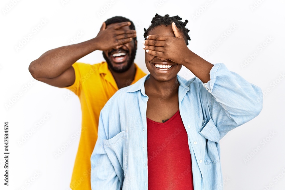 Young african american couple wearing casual clothes smiling and laughing with hand on face covering eyes for surprise. blind concept.