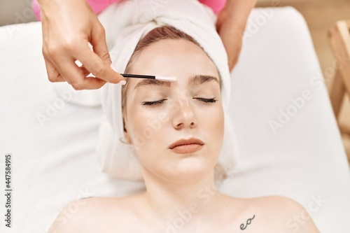 Woman reciving eyebrows treatment at beauty center.