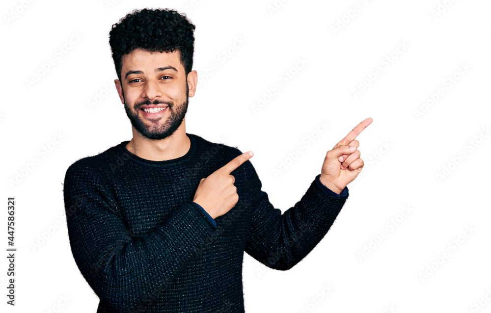 Young arab man with beard wearing casual winter sweater smiling and looking at the camera pointing with two hands and fingers to the side. Young arab man with beard wearing casual winter sweater smiling and looking at the camera pointing with two hands and fingers to the side.