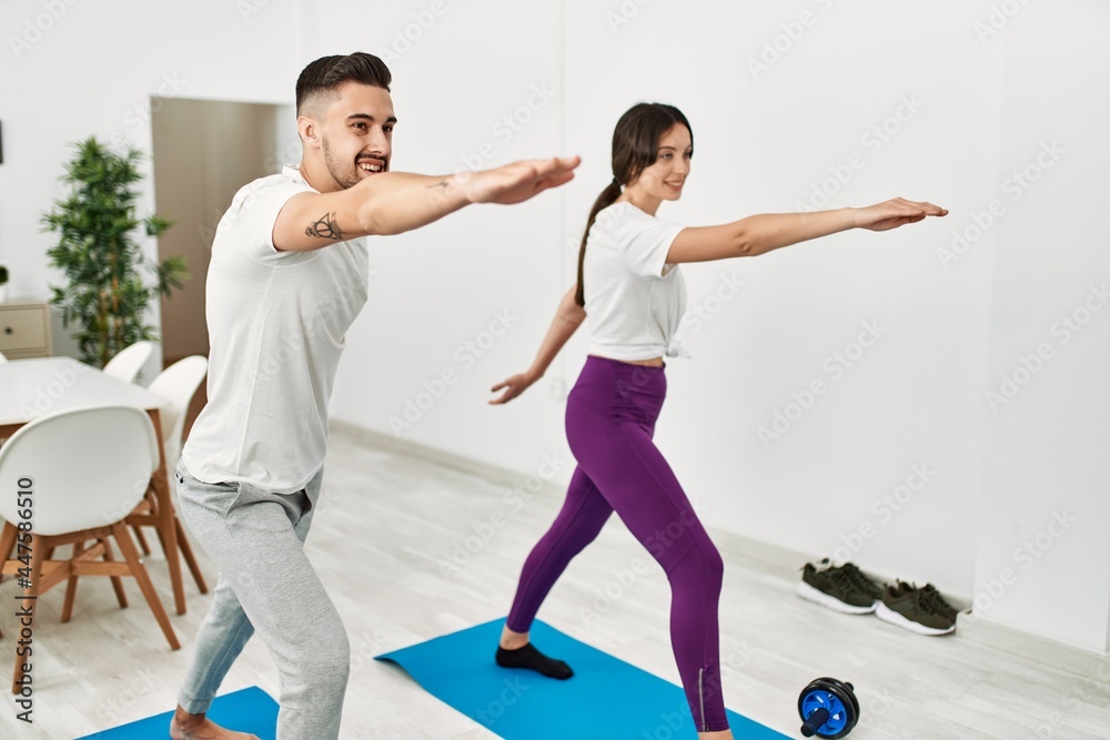 Young hispanic couple doing yoga at home Young hispanic couple doing yoga at home