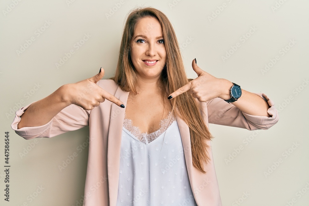 Young blonde woman wearing business jacket and glasses looking confident with smile on face, pointing oneself with fingers proud and happy. Young blonde woman wearing business jacket and glasses looking confident with smile on face, pointing oneself with fingers proud and happy.