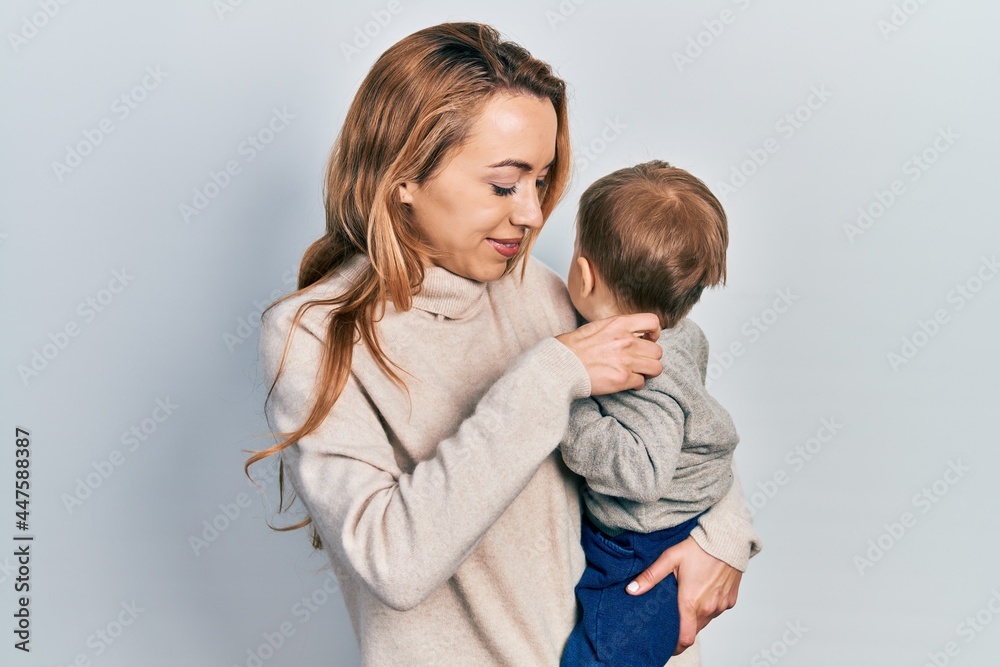 Young caucasian woman holding and hugging her son with love. Family of two bonding together. Mother holding infant toddler Young caucasian woman holding and hugging her son with love. Family of two bonding together. Mother holding infant toddler