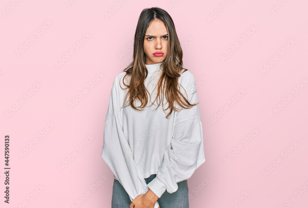 Young brunette woman wearing casual turtleneck sweater skeptic and nervous, frowning upset because of problem. negative person. Young brunette woman wearing casual turtleneck sweater skeptic and nervous, frowning upset because of problem. negative person.