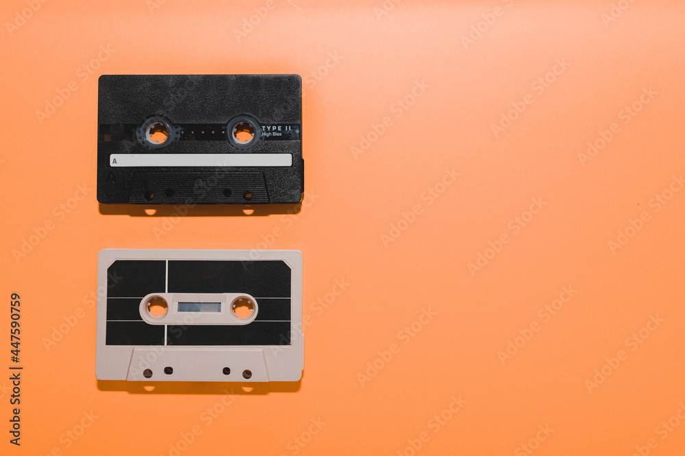 Two audio cassette tapes isolated on orange background. Copy space Two audio cassette tapes isolated on orange background. Copy space