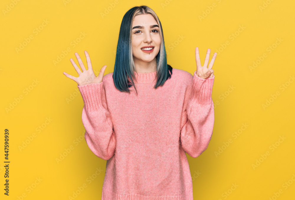 Young modern girl wearing pink wool winter sweater showing and pointing up with fingers number eight while smiling confident and happy. Young modern girl wearing pink wool winter sweater showing and pointing up with fingers number eight while smiling confident and happy.
