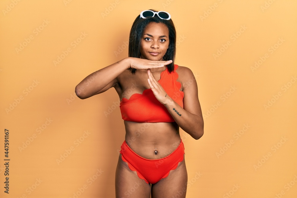 Young african american girl wearing bikini doing time out gesture with hands, frustrated and serious face Young african american girl wearing bikini doing time out gesture with hands, frustrated and serious face