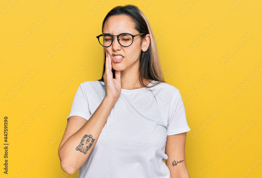 Young hispanic woman wearing casual white t shirt touching mouth with hand with painful expression because of toothache or dental illness on teeth. dentist