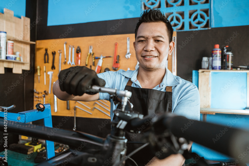 a bicycle mechanic uses a tool to unscrew the handlebar bolts while repairing a bicycle in a repair shop a bicycle mechanic uses a tool to unscrew the handlebar bolts while repairing a bicycle in a repair shop
