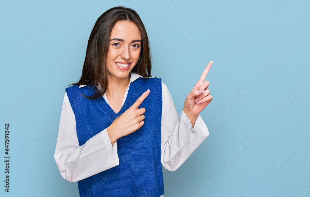 Young hispanic girl wearing casual clothes smiling and looking at the camera pointing with two hands and fingers to the side. Young hispanic girl wearing casual clothes smiling and looking at the camera pointing with two hands and fingers to the side.