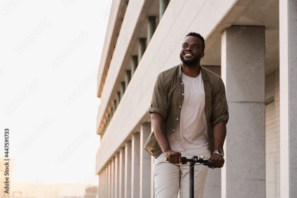 Young african american man using electric scooter outdoor in the city - Focus on face