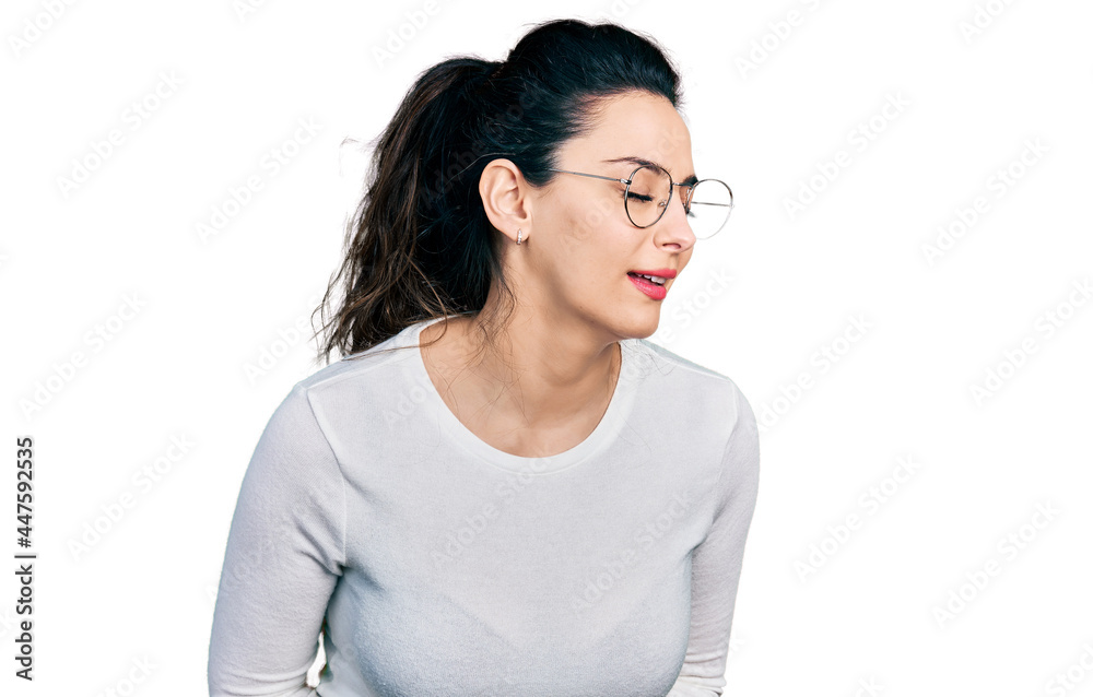 Young hispanic woman wearing casual clothes with hand on stomach because nausea, painful disease feeling unwell. ache concept. Young hispanic woman wearing casual clothes with hand on stomach because nausea, painful disease feeling unwell. ache concept.