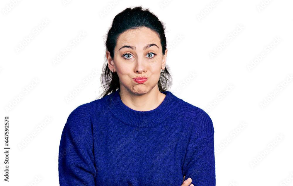 Young hispanic woman with arms crossed gesture puffing cheeks with funny face. mouth inflated with air, catching air. Young hispanic woman with arms crossed gesture puffing cheeks with funny face. mouth inflated with air, catching air.