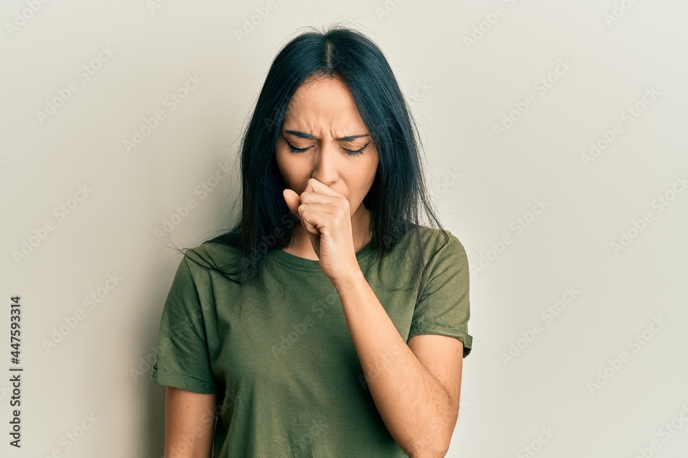 Young hispanic girl wearing casual t shirt feeling unwell and coughing as symptom for cold or bronchitis. health care concept. Young hispanic girl wearing casual t shirt feeling unwell and coughing as symptom for cold or bronchitis. health care concept.