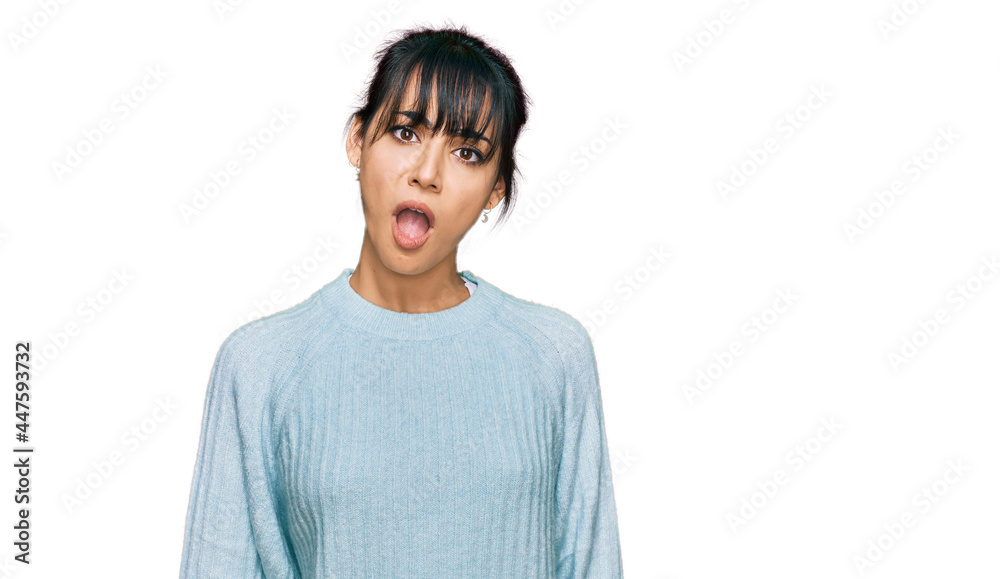 Young hispanic woman wearing casual clothes in shock face, looking skeptical and sarcastic, surprised with open mouth Young hispanic woman wearing casual clothes in shock face, looking skeptical and sarcastic, surprised with open mouth