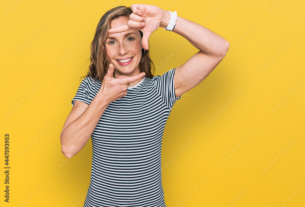 Young blonde woman wearing casual clothes smiling making frame with hands and fingers with happy face. creativity and photography concept. Young blonde woman wearing casual clothes smiling making frame with hands and fingers with happy face. creativity and photography concept.