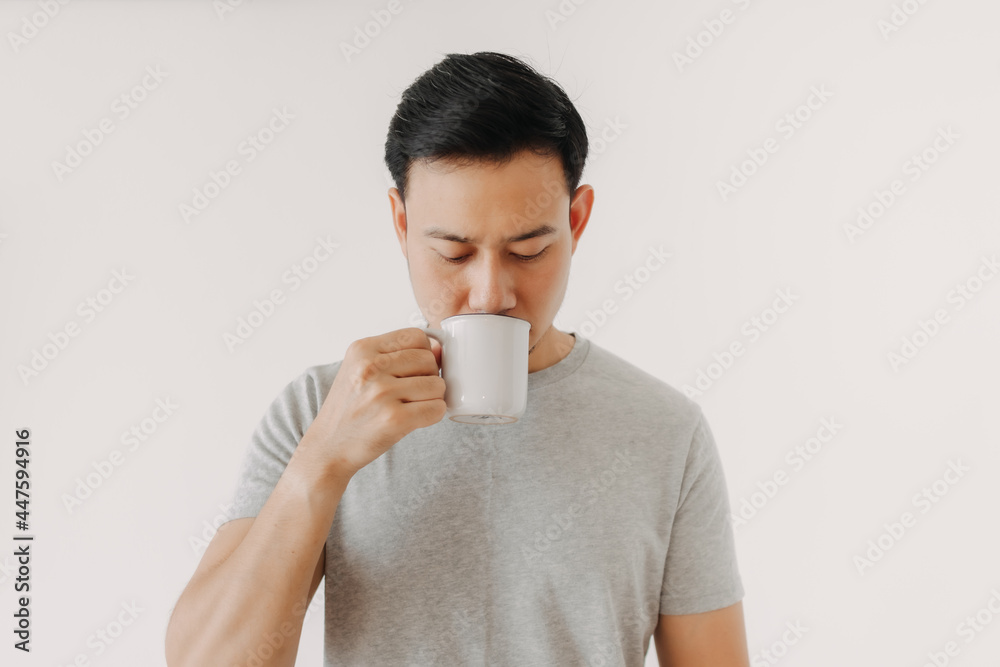 Asian man is drinking coffee or tea isolated on white background. Asian man is drinking coffee or tea isolated on white background.