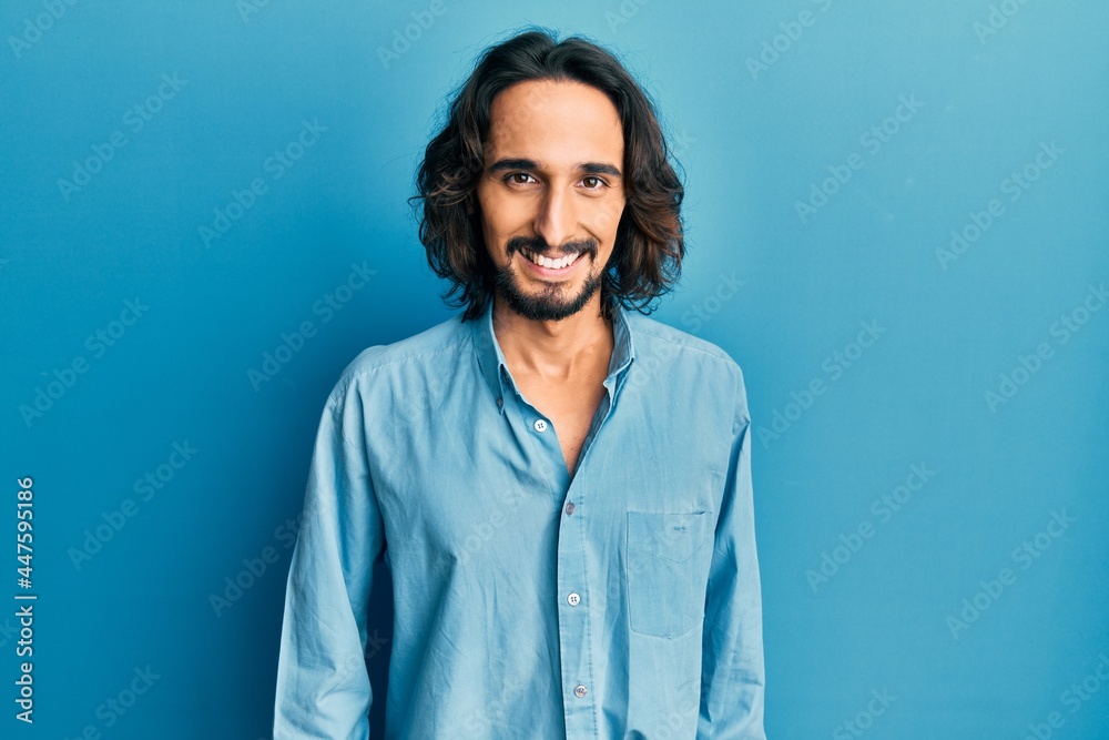 Young hispanic man wearing casual clothes with a happy and cool smile on face. lucky person. Young hispanic man wearing casual clothes with a happy and cool smile on face. lucky person.