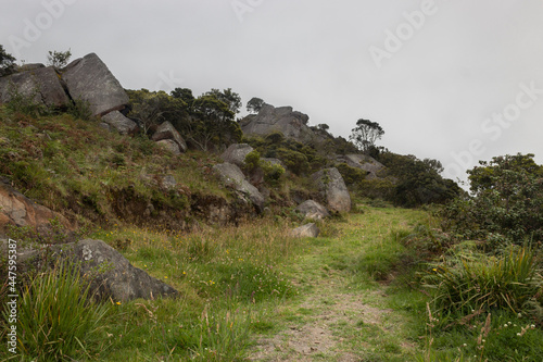 An old rural path with ancient sacred monoliths to colombian muisca culture in middle of andean countryside and cloudy sky photo