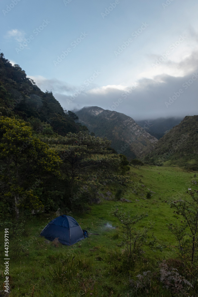 Blue tend camping near to a forest mountain in middle of colombian andean mountains valley early in the morning