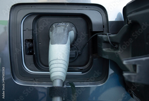 Charging an electric car. Close-up of a power source connected to a charging electrical vehicle.