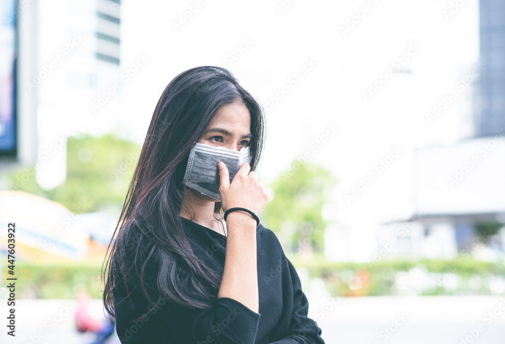Fototapeta premium Face of Asian woman wearing a face mask for protection virus or pollution with outdoor city background. coronavirus protect. Sick and other protect such as Air, Dirt, Fever. Health concept. New Normal
