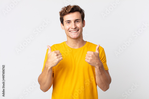 Cuadro en lienzo young handsome man smiling joyfully and looking happy, feeling carefree and posi