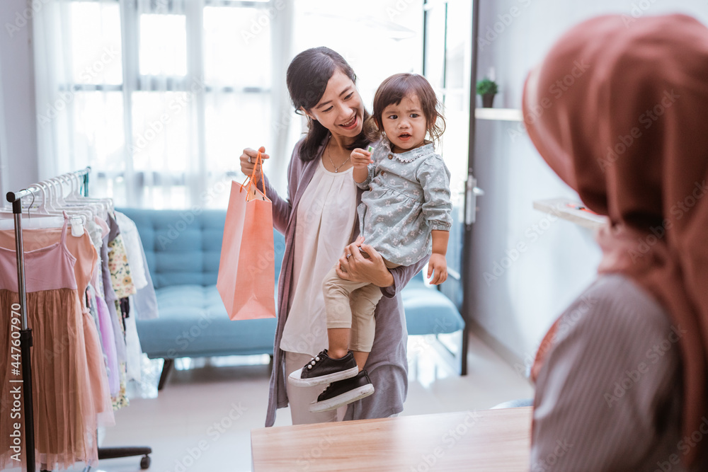 Fototapeta premium mother and kid shopping in the mall buying some clothes