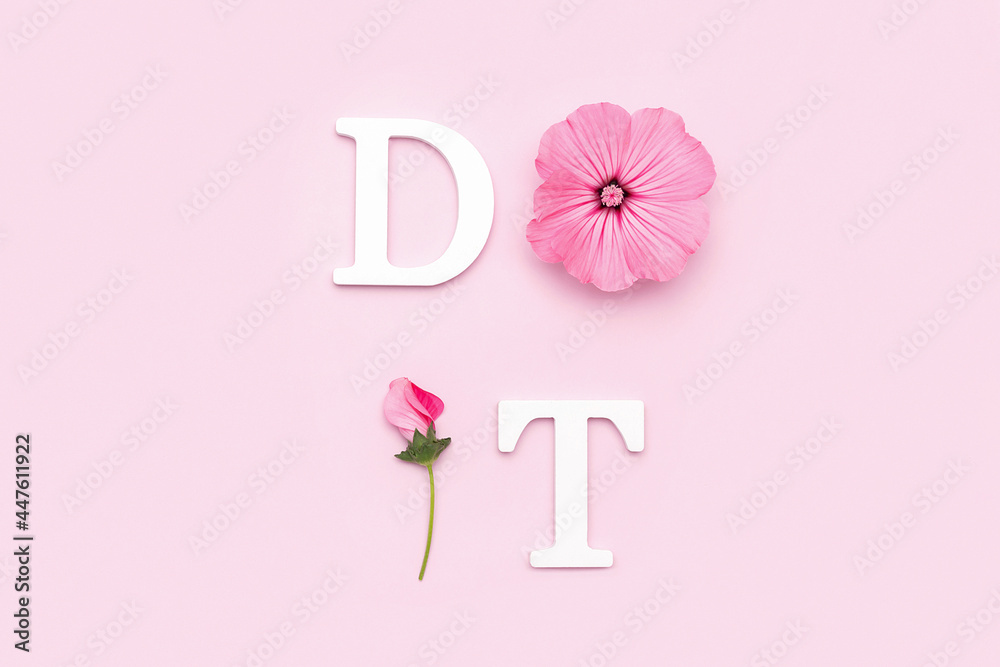 Do it. Motivational quote from white letters and beauty natural flowers on pink background. Creative concept inspirational quote of the day Do it. Motivational quote from white letters and beauty natural flowers on pink background. Creative concept inspirational quote of the day