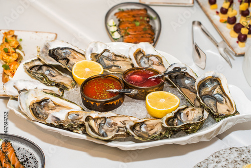 Fresh Oysters close-up. served table, lemon and ice. Healthy seafood. Fresh Oyster dinner in restaurant. Gourmet food photo