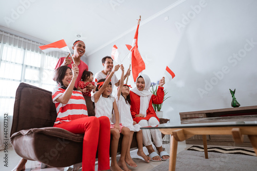 excited indonesian family supporter while watching sport match at television at home