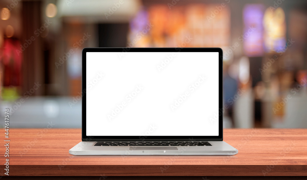 Laptop or notebook with blank screen on wood table in blurry background with fast food restaurant or coffee shop ,nature orange bokeh and sunlight in morning. Laptop or notebook with blank screen on wood table in blurry background with fast food restaurant or coffee shop ,nature orange bokeh and sunlight in morning.