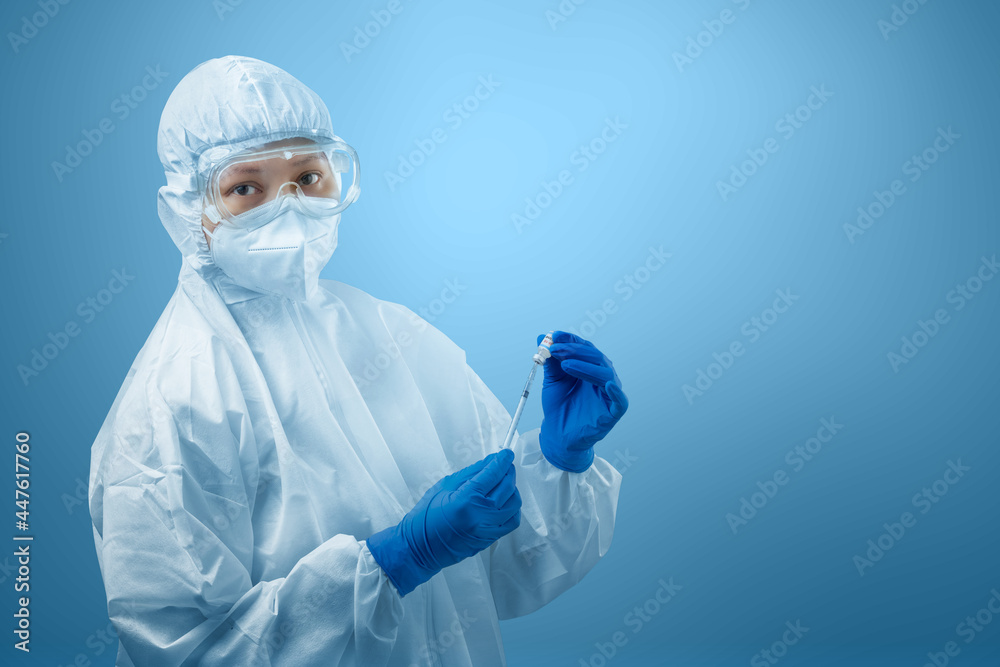 Health worker woman with a protective suit and gloves holding covid 19 vaccines Health worker woman with a protective suit and gloves holding covid 19 vaccines