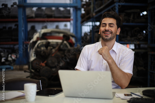 Businessman using laptop computer working or checking stock in warehouse factory, entrepreneurship or business owner concept