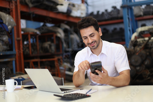 Businessman using laptop computer working or checking stock in warehouse factory, entrepreneurship or business owner concept