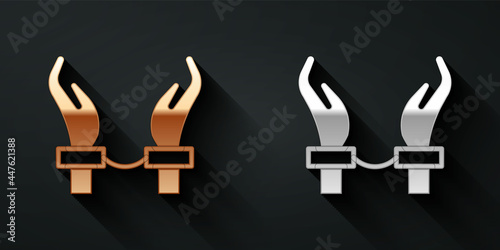 Gold and silver Handcuffs on hands of criminal man icon isolated on black background. Arrested man in handcuffs. A crime, arrest, business and corruption concept. Long shadow style. Vector