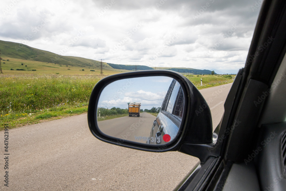 Car mirror and highway view, black car and nature landscape