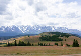 snowy peaks of mountains and steppe on a background of cloudy sky