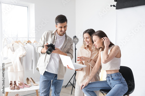Stylist and photographer working with model in studio