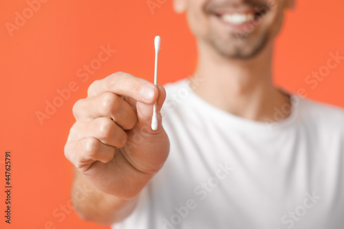 Young man with cotton bud o...