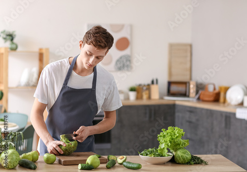 Young man cutting broccoli ...