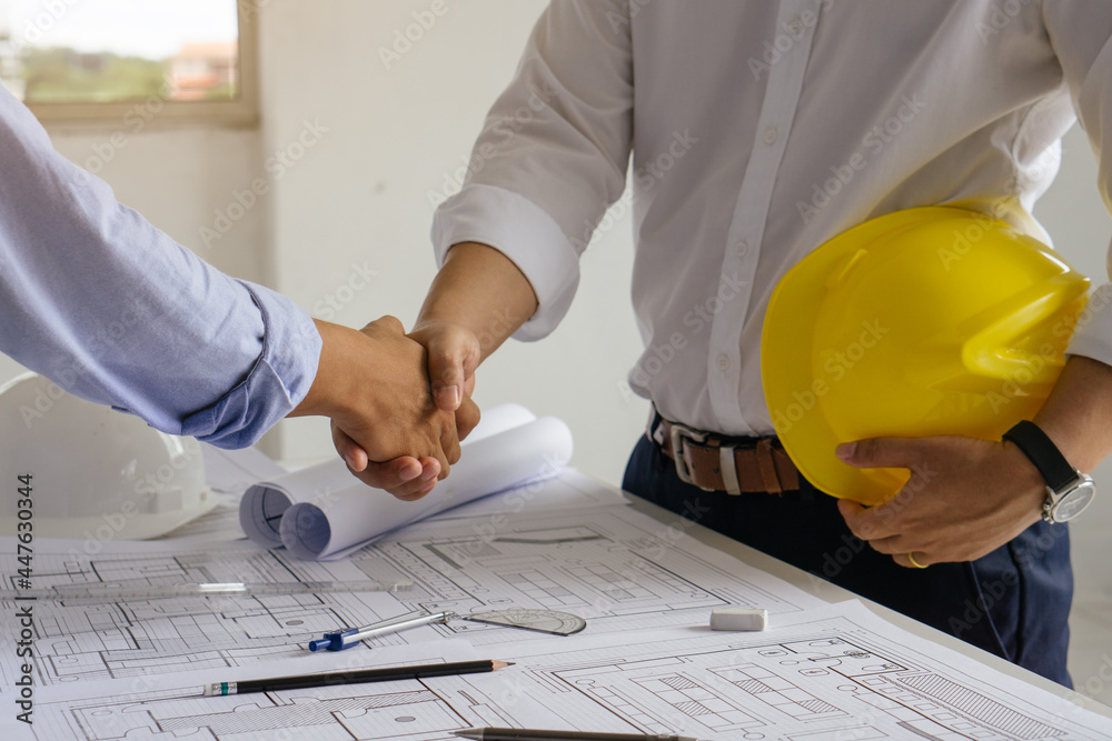 Architect and engineer shaking hands after finish an agreement in the office construction site, success collaboration concept. Architect and engineer shaking hands after finish an agreement in the office construction site, success collaboration concept.