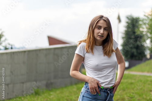 Portrait of a young woman in white t-shirt. Outdoor photo. photo