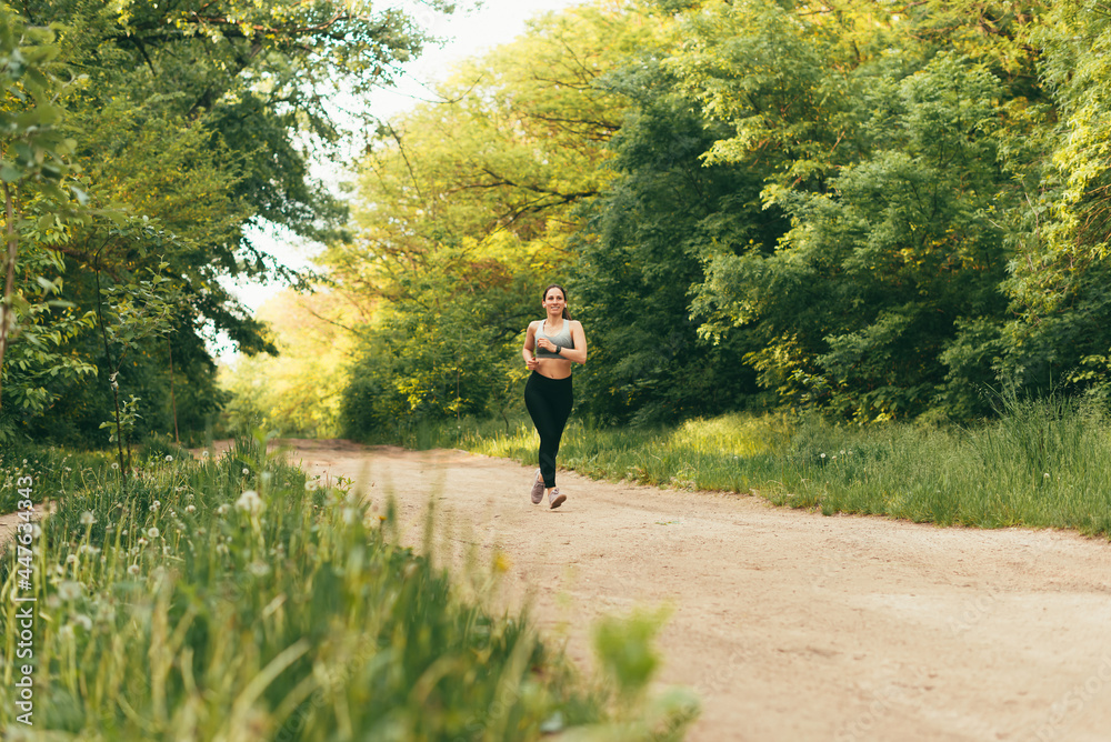 Woman running road summer park, sporty female morning workout. Healthy lifestyle concept. Woman running road summer park, sporty female morning workout. Healthy lifestyle concept.