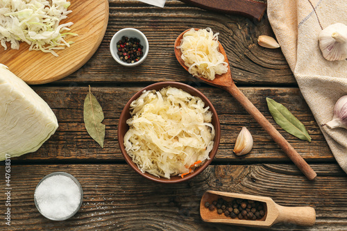 Composition with tasty sauerkraut on wooden table