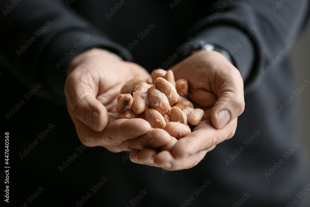 Man holding fresh cocoa beans, closeup Man holding fresh cocoa beans, closeup