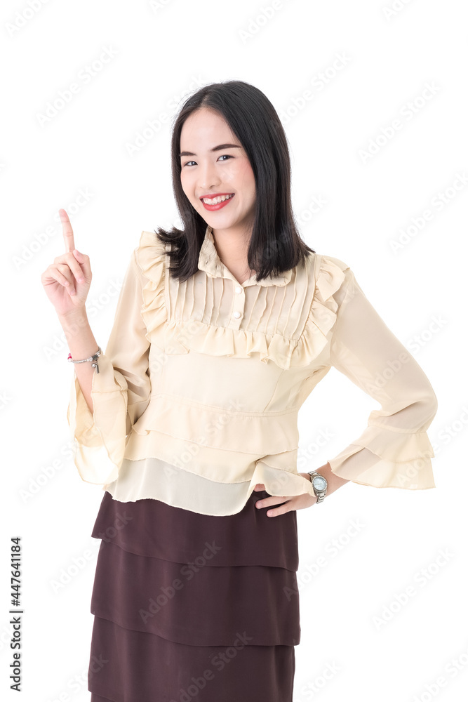 Vertical portrait shot of a cute smiling young Asian woman looking at the camera while pointing to the side of the image to presenting and showing advertising product isolated on white background Vertical portrait shot of a cute smiling young Asian woman looking at the camera while pointing to the side of the image to presenting and showing advertising product isolated on white background