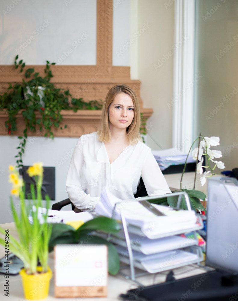 Portrait of a beautiful  businesswoman sitting near her workplace in modern office